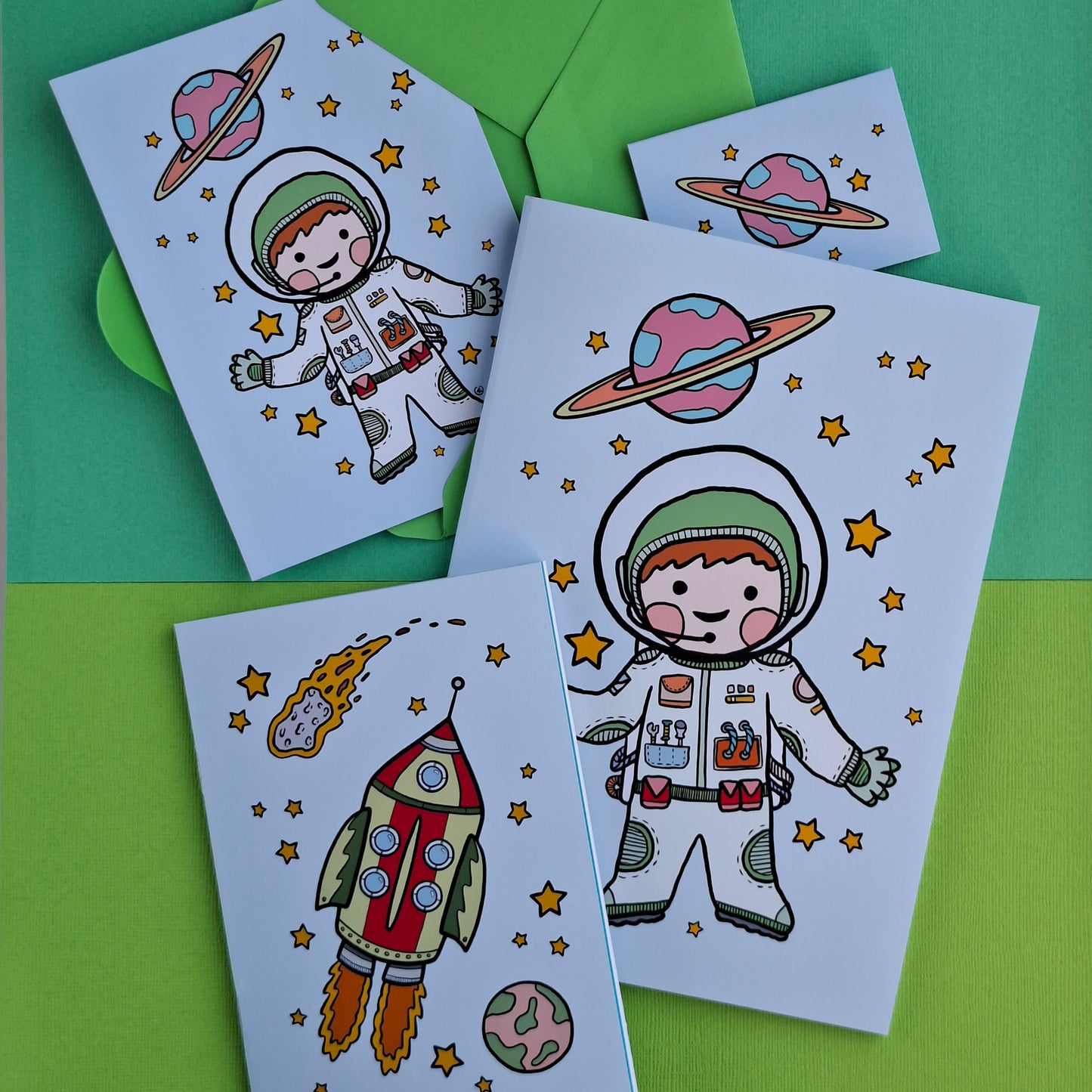 Illustrerad astronaut och raket på anteckningsbok och gratulationskort.