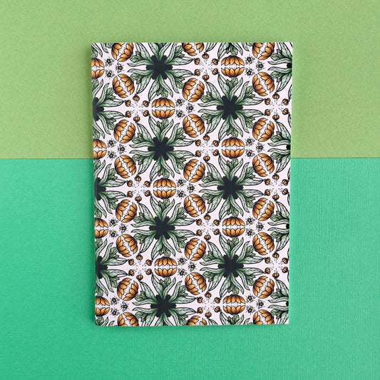 Anteckningsbok med mönster av blommor och bin.