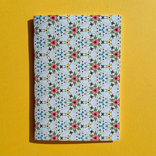 Anteckningsbok med blommor och fjärilar som mönster.